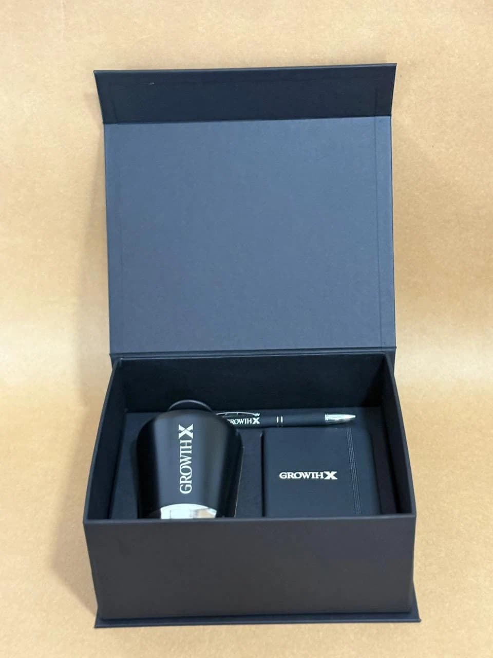 Kit corporativo real em caixa azul com garrafa e caderno personalizados da Casa das Lembrancinhas em Goiânia